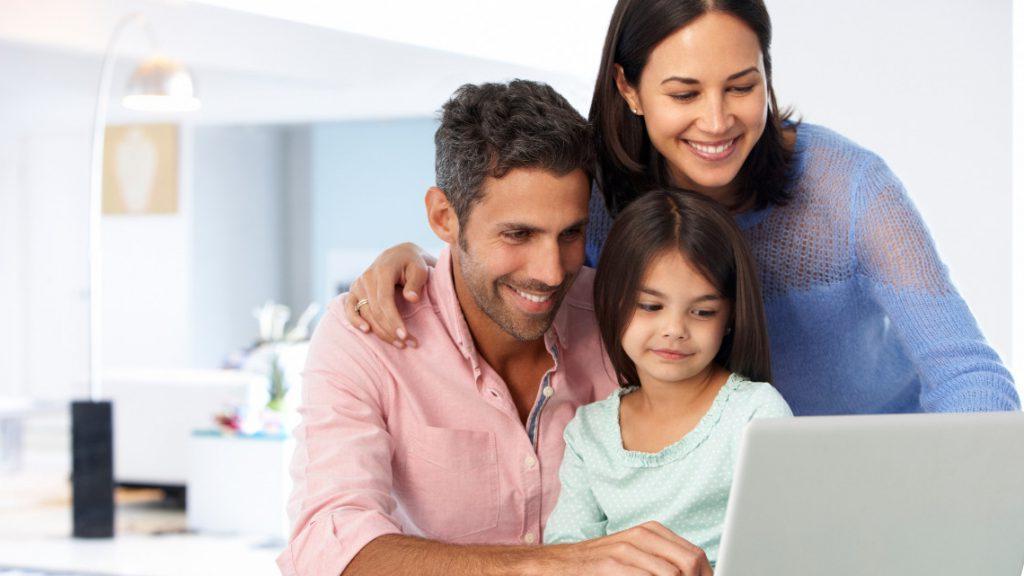 一个微笑的家庭在笔记本电脑前一起工作的画面
